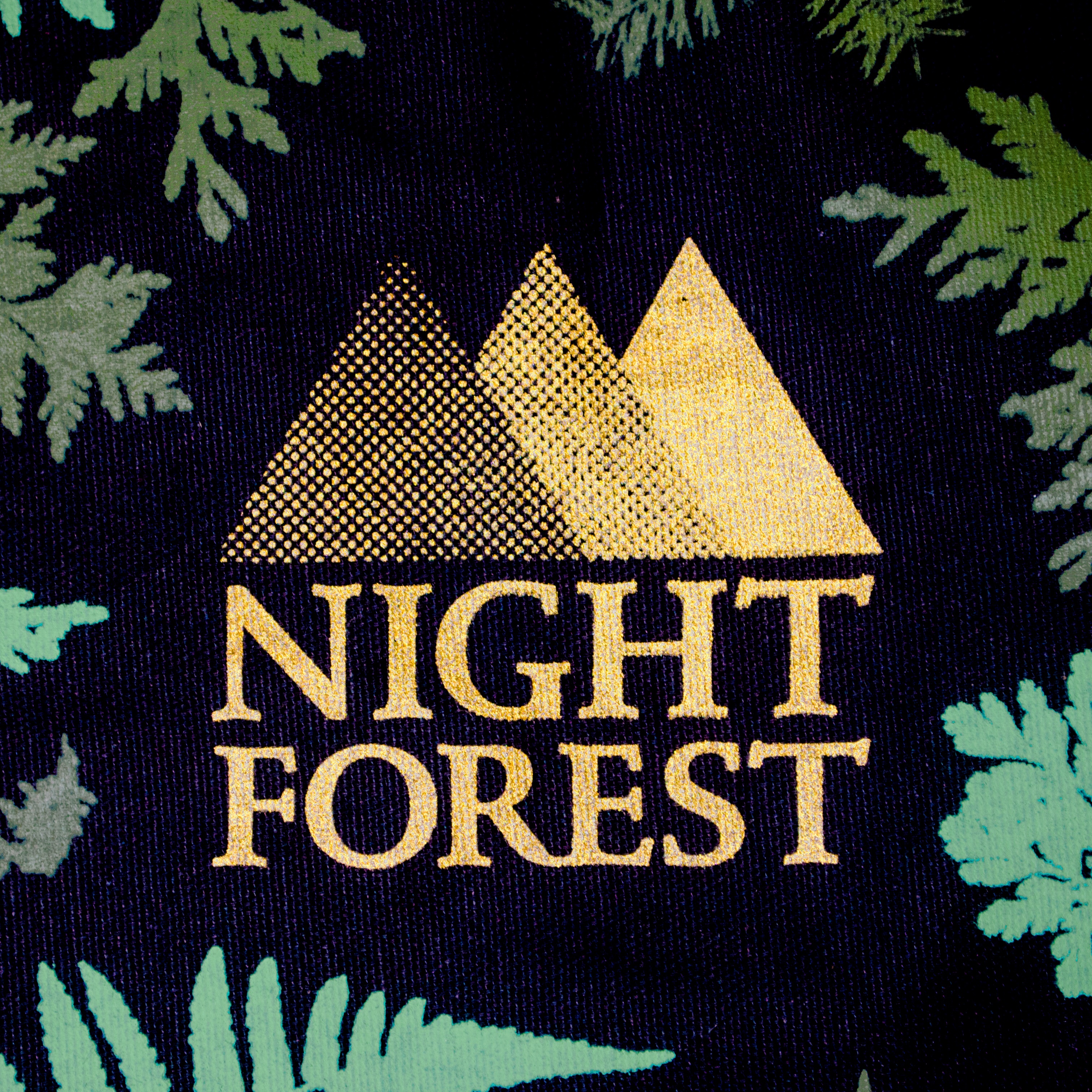 Night Forest logo, screenprinted in gold on a black fabric with dark teal branches around